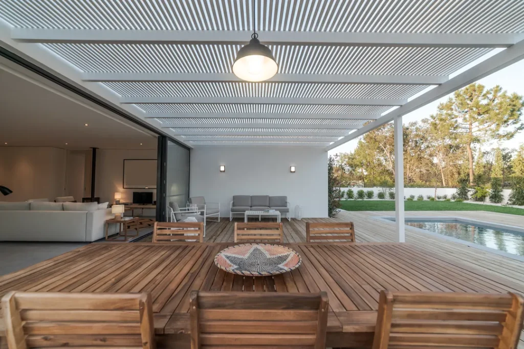 Pergola adosada a una casa blanca moderna